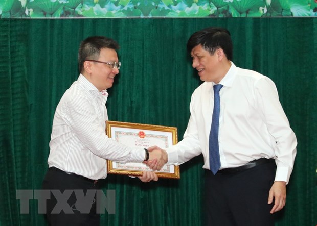 Thứ trưởng Bộ Y tế Nguyễn Thanh Long trao Bằng khen cho nhà báo Lê Quốc Minh, Phó Tổng giám đốc TTXVN.