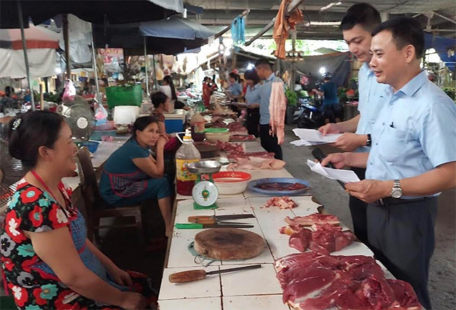 Cán bộ bảo hiểm xã hội tỉnh tuyên truyền, vận động người kinh doanh tại chợ Yên Thịnh, thành phố Yên Bái tham gia bảo hiểm xã hội tự nguyện.