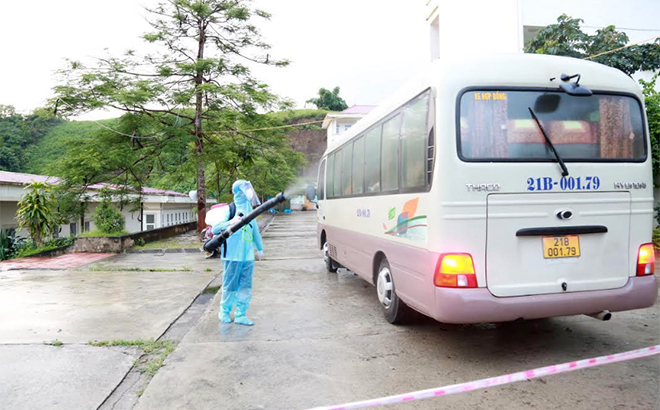 Cán bộ y tế phun khử khuẩn phương tiện đón người hoàn thành cách ly tập trung tại tỉnh Bắc Giang về cách ly tập trung tại Yên Bái.