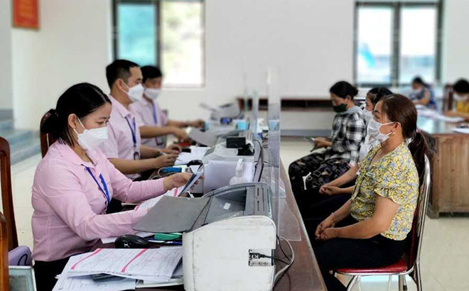 Cán bộ Phòng Giao dịch Ngân hàng Chính sách xã hội huyện Yên Bình làm thủ tục giải ngân vốn cho người dân ở xã Phúc Ninh theo Nghị quyết 11 của Chính phủ.