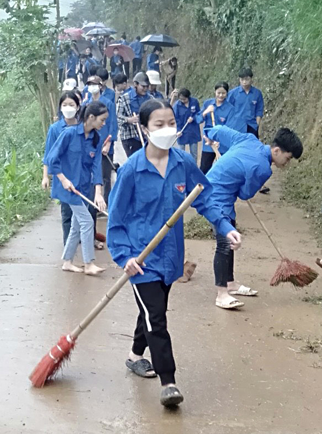 Đoàn viên thanh niên xã Cảm Ân tham gia vệ sinh môi trường đường giao thông nông thôn.