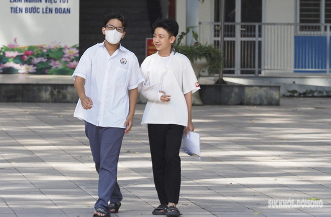 Học sinh lớp 8 ghi bài hộ thí sinh bị gãy tay trong kỳ thi lớp 10 ở Hà Nội.