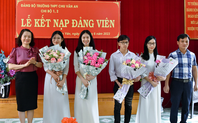 Các đồng chí lãnh đạo huyện Văn Yên tặng hoa chúc mừng các đảng viên mới là học sinh của Đảng bộ Trường THPT Chu Văn An