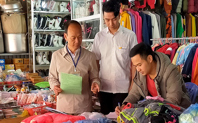Cán bộ Chi cục Thuế huyện Mù Cang Chải tuyên truyền chính sách thuế mới tại chợ trung tâm huyện.