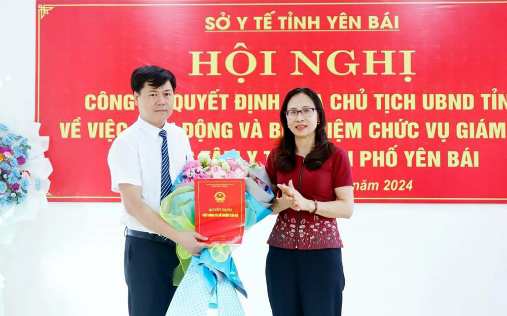Đồng chí Giám đốc Sở Y tế Lê Thị Hồng Vân trao Quyết định của UBND tỉnh và tặng hoa chúc mừng tân Giám đốc Trung tâm Y tế thành phố.