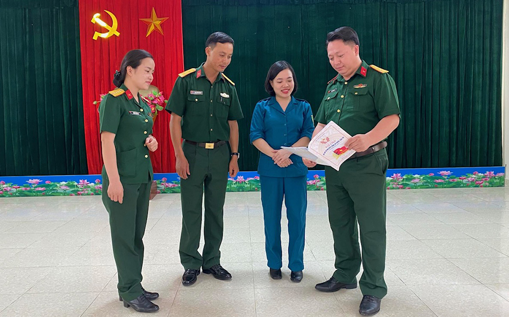Chính trị viên phó, Ban Chỉ huy Quân sự khối Đảng, đoàn thể huyện Trấn Yên trao đổi với cán bộ Ban Chỉ huy Quân sự huyện về công tác giáo dục quốc phòng.