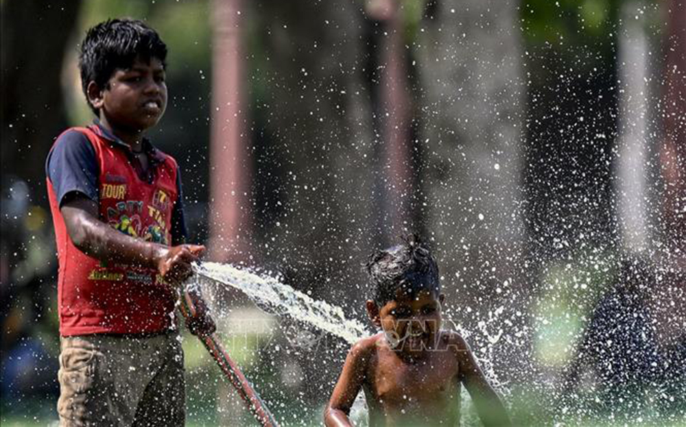 Trẻ em chơi đùa với nước trong ngày nắng nóng tại New Delhi, Ấn Độ, ngày 31/5/2024.