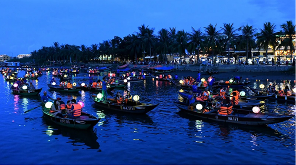 Du khách đi thuyền trên sông Hoài tham quan phố cổ Hội An vào ban đêm.
