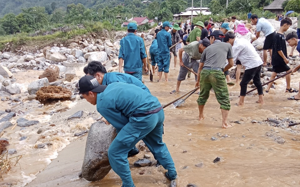 Các lực lượng tham gia cùng người dân thôn Khe Dẹt, xã Phong Dụ Thượng, huyện Văn Yên khắc phục hậu quả sau lũ ống, bảo đảm giao thông đi lại an toàn.