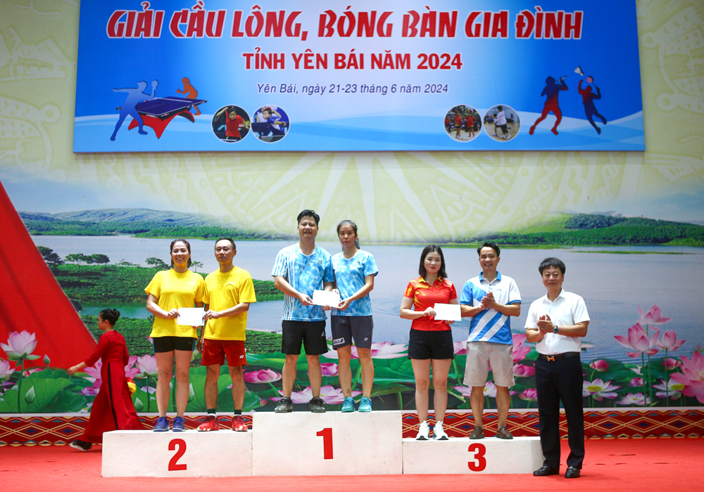 Ban tổ chức trao giải cho các cặp vận động viên có thành tích xuất sắc môn cầu lông ở nội dung đôi vợ chồng nhóm 2.