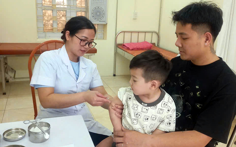 Cán bộ Trung tâm Y tế thành phố Yên Bái tiêm phòng cho trẻ.