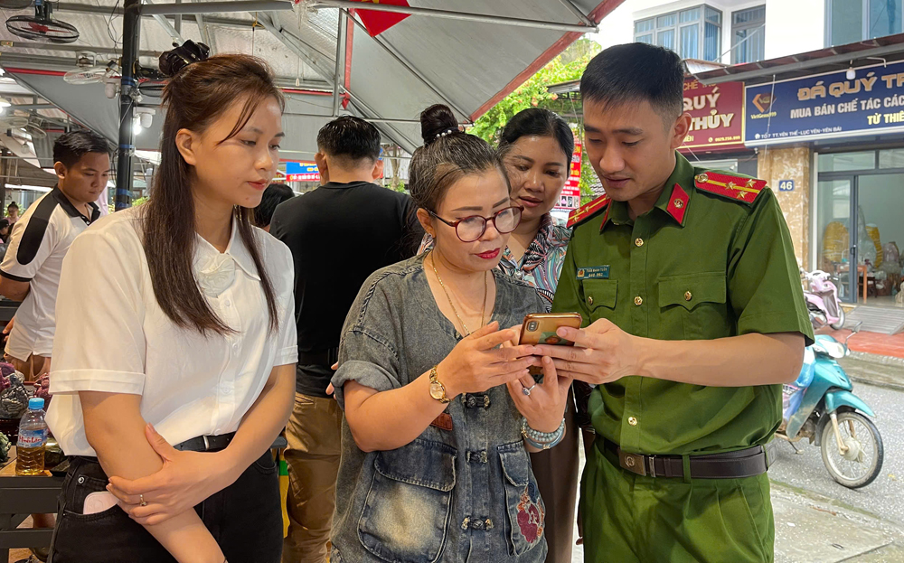 Cán bộ công an thị trấn Yên Thế hướng dẫn người dân sử dụng ứng dụng VNeID để góp ý sửa đổi, bổ sung Hiến pháp 2013.
