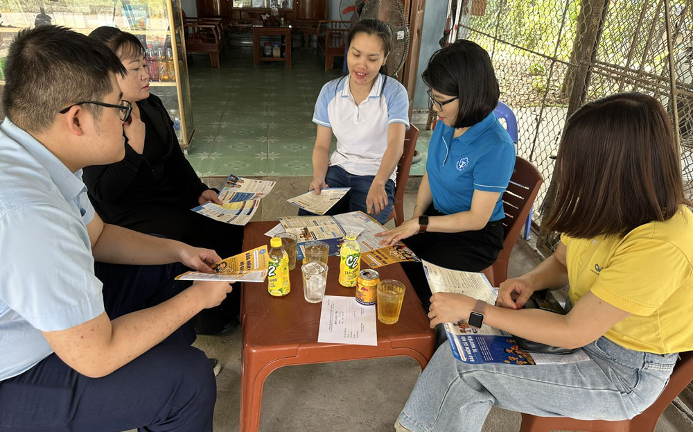 Viên chức BHXH Khu vực XVII tuyên truyền, vận động người dân xã Giới Phiên, thành phố Yên Bái tham gia BHYT hộ gia đình.