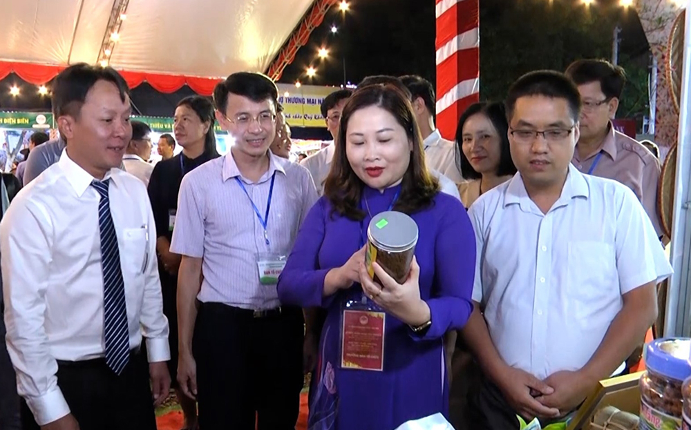 Các đồng chí: Vũ Thị Hiền Hạnh - Phó Chủ tịch UBND tỉnh (thứ 2, từ phải sang) và Nguyễn Đình Chiến - Phó Giám đốc Sở Công Thương tỉnh (ngoài cùng, bên trái) tham quan các sản phẩm OCOP của thị xã Nghĩa Lộ.