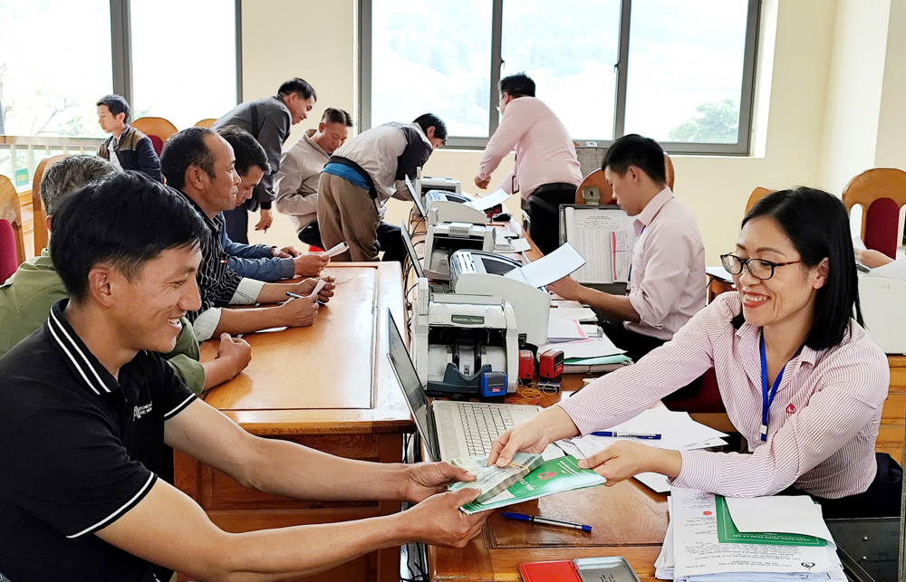 Cán bộ NHCSXH huyện Mù Cang Chải giải ngân vốn cho người dân trên địa bàn huyện.