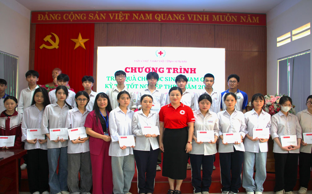 Đại diện lãnh đạo Hội Chữ thập đỏ tỉnh và Trường THPT Nguyễn Huệ trao quà cho học sinh có hoàn cảnh khó khăn của Trường THPT Nguyễn Huệ.