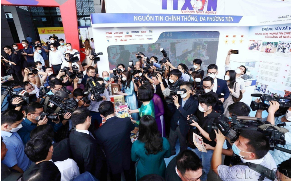 Phóng viên đưa tin về Gian trưng bày của Thông tấn xã Việt Nam tại Hội Báo toàn quốc năm 2022.