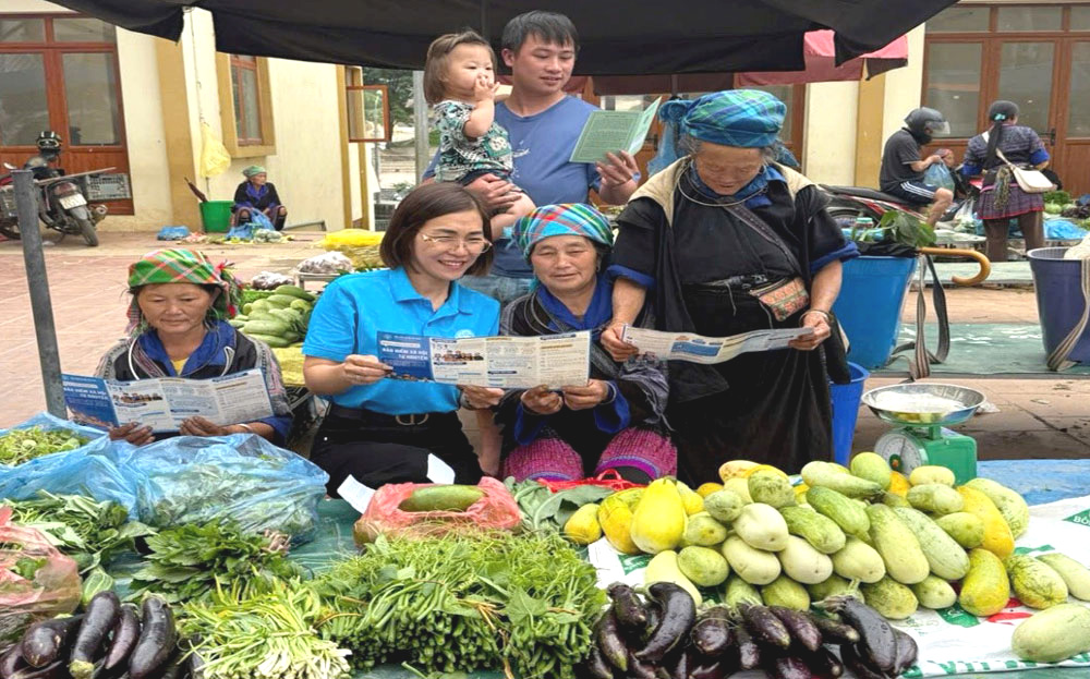 Viên chức BHXH liên huyện Nghĩa Lộ - Mù Cang Chải tuyên truyền, vận động đăng nhập dafabet dân tham gia BHXH tự nguyện tại chợ trung tâm huyện Mù Cang Chải.