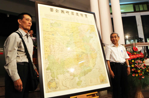 TS Mai Hồng (người đeo túi) trao bản đồ cho PGS-TS Nguyễn Văn Chiến, Phó giám đốc Bảo tàng Lịch sử quốc gia - Ảnh: Ngô Vương Anh
