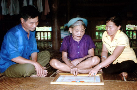 Bà Nguyễn Thị Quỵ (ngồi giữa) trao đổi với lãnh đạo Hội Phụ nữ xã Mường Lai.
