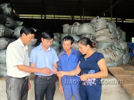 Chủ tịch UBND xã Âu Lâu - đồng chí Lê Toàn Thắng (thứ 2, trái sang) trao đổi về mẫu mã sản phẩm chè với công nhân và chủ doanh nghiệp chè Phấn Đào ở thôn Đắng Con. 
