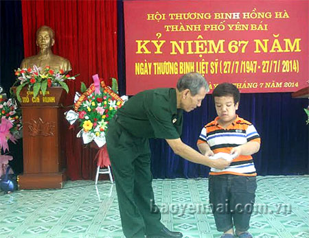 Ông Trần Quang Lưu  - Chủ tịch Hội Thương binh Hồng Hà trao quà cho con, cháu hội viên đạt danh hiệu học sinh giỏi.