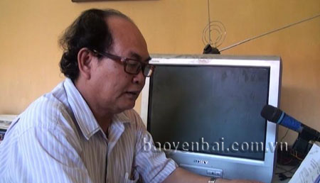 Ông Đoàn Xuân Hồng đang đọc bản tin của phường.
