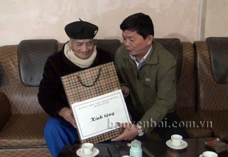 Đồng chí Trần Văn Mộc - Bí thư Huyện ủy Văn Chấn thăm, tặng quà ông Hoàng Công Tác, là gia đình chính sách ở xã Đồng Khê (Văn Chấn).
