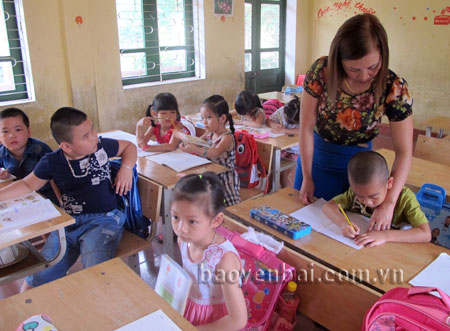 Cô giáo Phạm Thị Thành đang hướng dẫn học sinh tập viết.

