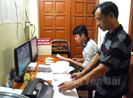 Anh Bùi Xuân Lâm (người đứng) cùng cán bộ Văn phòng 
Xổ số huyện Trấn Yên nhập số liệu bán vé của đại lý trên địa bàn gửi về Công ty theo quy định.