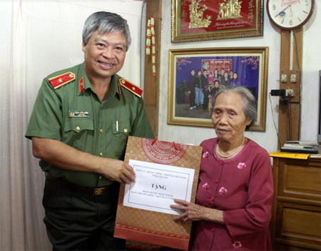 Đồng chí Đặng Trần Chiêu - Giám đốc Công an tỉnh thăm và tặng quà cụ Lương Thị Len, vợ liệt sỹ.