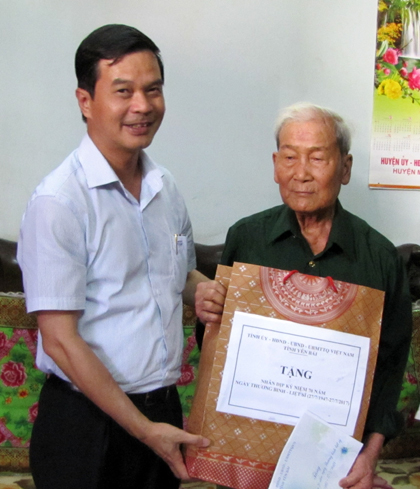 Đồng chí Dương Văn Tiến - Phó Chủ tịch UBND tỉnh tặng quà ông Nguyễn Văn Hứ,thị trấn Mù Cang Chải.
