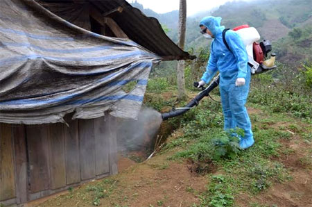 Cán bộ Trung tâm Kiểm soát bệnh tật tỉnh phun hoá chất diệt muỗi cho hộ dân tại thôn Khe Kẹn, xã Cát Thịnh, huyện Văn Chấn.