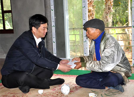 Đồng chí Nguyễn Minh Toàn – Bí thư Huyện ủy Yên Bình trao tiền hỗ trợ làm nhà cho ông Hầu Chí Quân – gia đình chính sách ở thôn Cây Thị, xã Yên Bình.