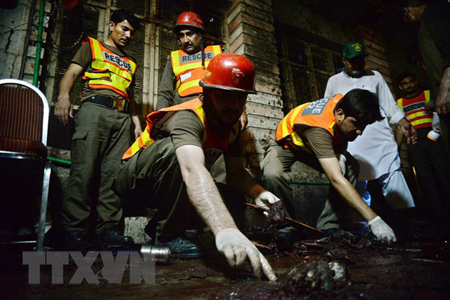Nhân viên cứu hộ Pakistan làm nhiệm vụ tại hiện trường vụ đánh bom đẫm máu ở Peshawar ngày 10/7.