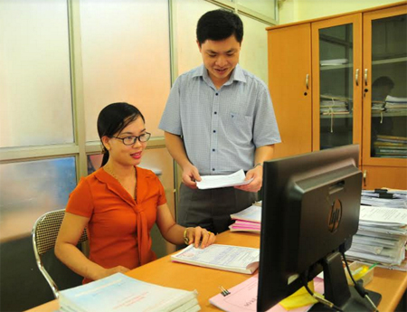 Cán bộ Chi cục Thuế huyện Trấn Yên trao đổi công tác thu liên quan đến khối doanh nghiệp.