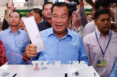 Thủ tướng Samdech Techo Hun Sen (giữa), Chủ tịch đảng Nhân dân Campuchia (CPP) cầm quyền bỏ phiếu tại điểm bầu cử ở Phnom Penh ngày 29-7.