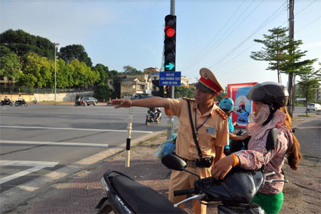 Lực lượng cảnh sát giao thông tuyên truyền, nhắc nhở người tham gia giao thông chấp hành quy định của vạch chỉ dẫn tại ngã tư Km5, thành phố Yên Bái.