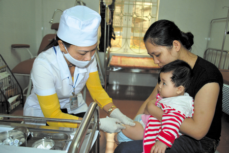 Cán bộ y tế phường Nguyễn Thái Học tiêm phòng sởi Rubella cho trẻ.