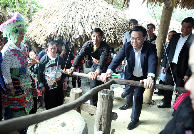 Phó Thủ tướng Vương Đình Huệ tham gia trải nghiệm xay gạo ở chợ người Mông, bản Sin Suối Hồ, Lai Châu.