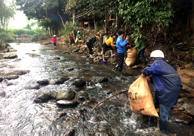 Thanh niên tình nguyện vớt rác dưới lòng suối xã Việt Hồng.