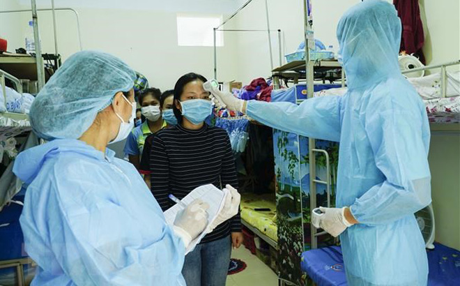 Nhân viên y tế đo thân nhiệt và kiểm tra sức khỏe cho các lưu học sinh Lào.