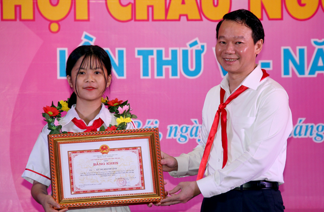 Chairman of the provincial People’s Committee Do Duc Duy presents merit certificates to children with outstanding achievements.