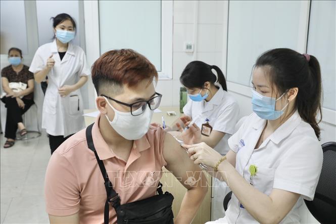 Nhân viên y tế tiêm thử nghiệm vaccine phòng COVID-19 cho tình nguyện viên.