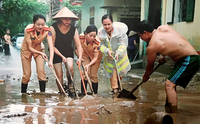 Cán bộ, hội viên Hội phụ nữ Công an tỉnh tham gia lao động giúp nhân dân khắc phục hậu quả sau mưa lũ.