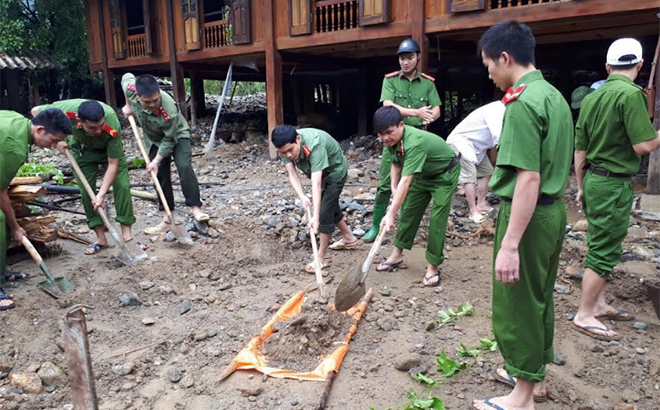 Cán bộ, chiến sĩ công an giúp người dân xã Sơn Lương, huyện Văn Chấn khắc phục hậu quả bão lũ năm 2018.