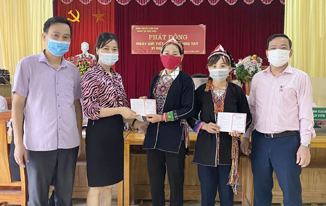 Chủ tịch HĐQT Phòng giao dịch NHCSXH huyện Văn Yên trao sổ tiết kiệm vì người nghèo cho các cá nhân xã Yên Thái.