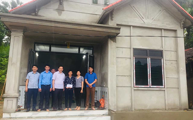 Lãnh đạo Ủy ban Mặt trận Tổ quốc huyện Yên Bình trao tiền hỗ trợ làm nhà cho hộ nghèo ở xã Ngọc Chấn.