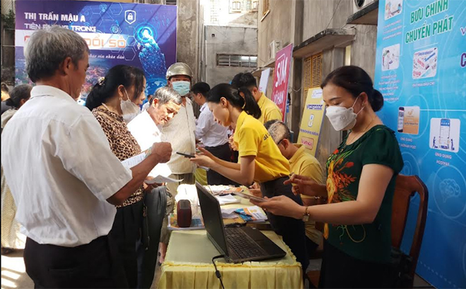 Nhân viên Bưu điện huyện Văn Yên hướng dẫn người dân thị trấn Mậu A cài đặt tài khoản định danh điện tử.