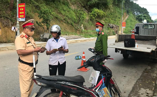 Cán bộ, chiến sĩ Đội Cảnh sát giao thông và Trật tự xã hội Công an huyện Mù Cang Chải tuyên truyền pháp luật về an toàn giao thông cho người dân.